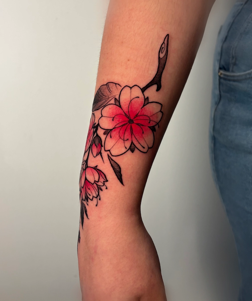 Tatouage de branche de cerisier noir et gris avec fleurs de sakura rouges – Jake Tattoo Parlor à Belfort.