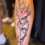 Tatouage cicatrisé d’Ichigo du manga Bleach en noir, gris et rouge sur un mollet – Jake Tattoo Parlor à Belfort.