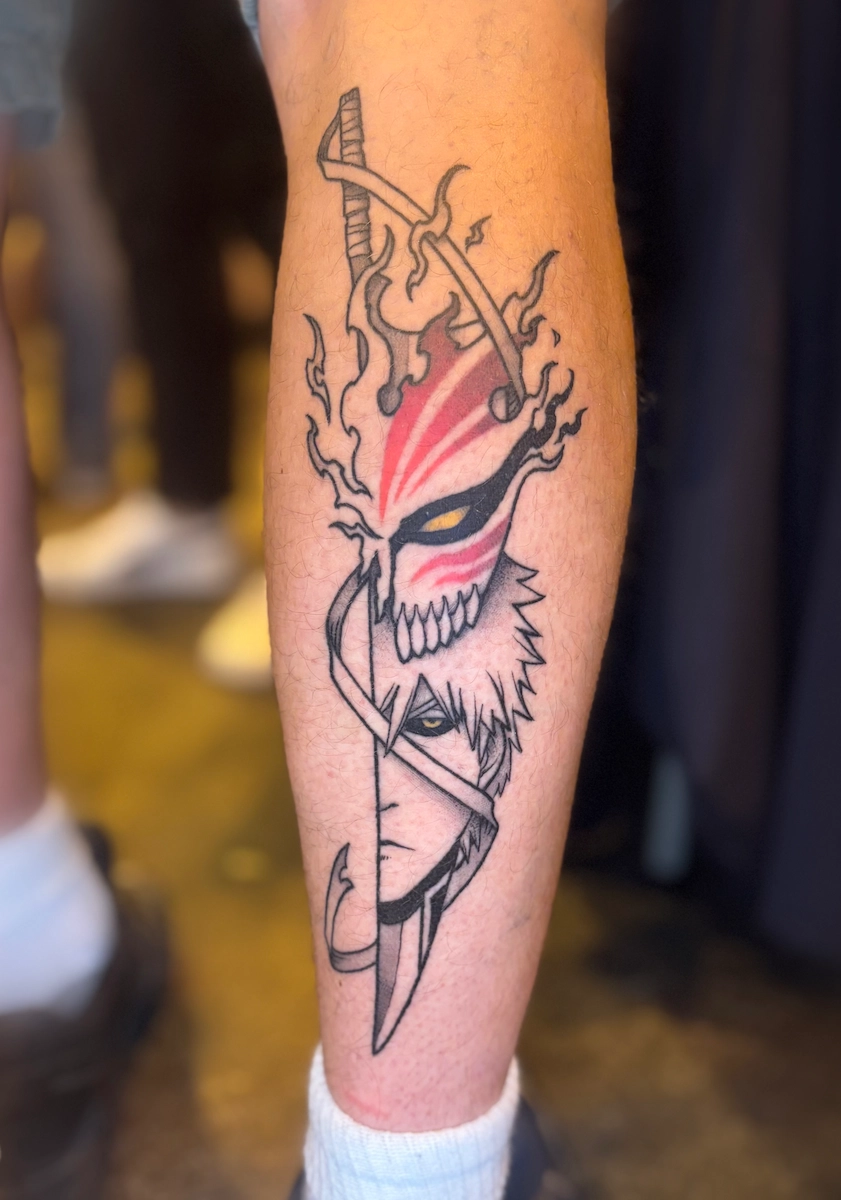 Tatouage cicatrisé d’Ichigo du manga Bleach en noir, gris et rouge sur un mollet – Jake Tattoo Parlor à Belfort.