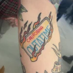 Tatouage couleur cicatrisé sur le thème Retour vers le Futur, représentant la plaque de la DeLorean – Jake Tattoo Parlor à Belfort.