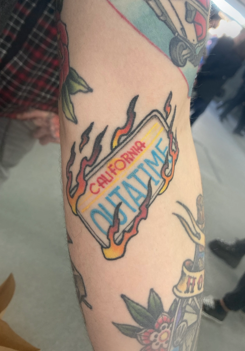 Tatouage couleur cicatrisé sur le thème Retour vers le Futur, représentant la plaque de la DeLorean – Jake Tattoo Parlor à Belfort.