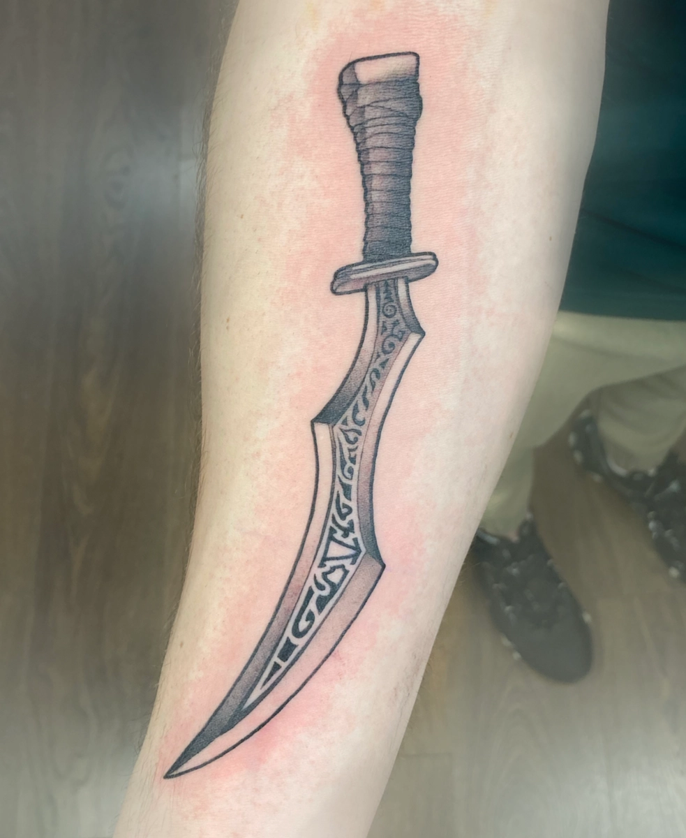 Tatouage noir et gris représentant une épée – Jake Tattoo Parlor à Belfort.