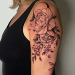 Tatouage féminin floral noir et gris sur l’épaule – Jake Tattoo Parlor à Belfort.