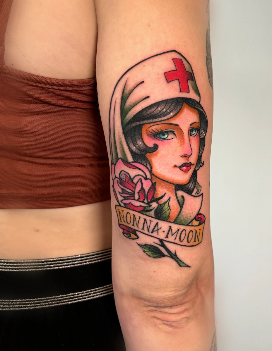 Tatouage néo-trad couleur représentant une infirmière sur le bras – Jake Tattoo Parlor à Belfort.