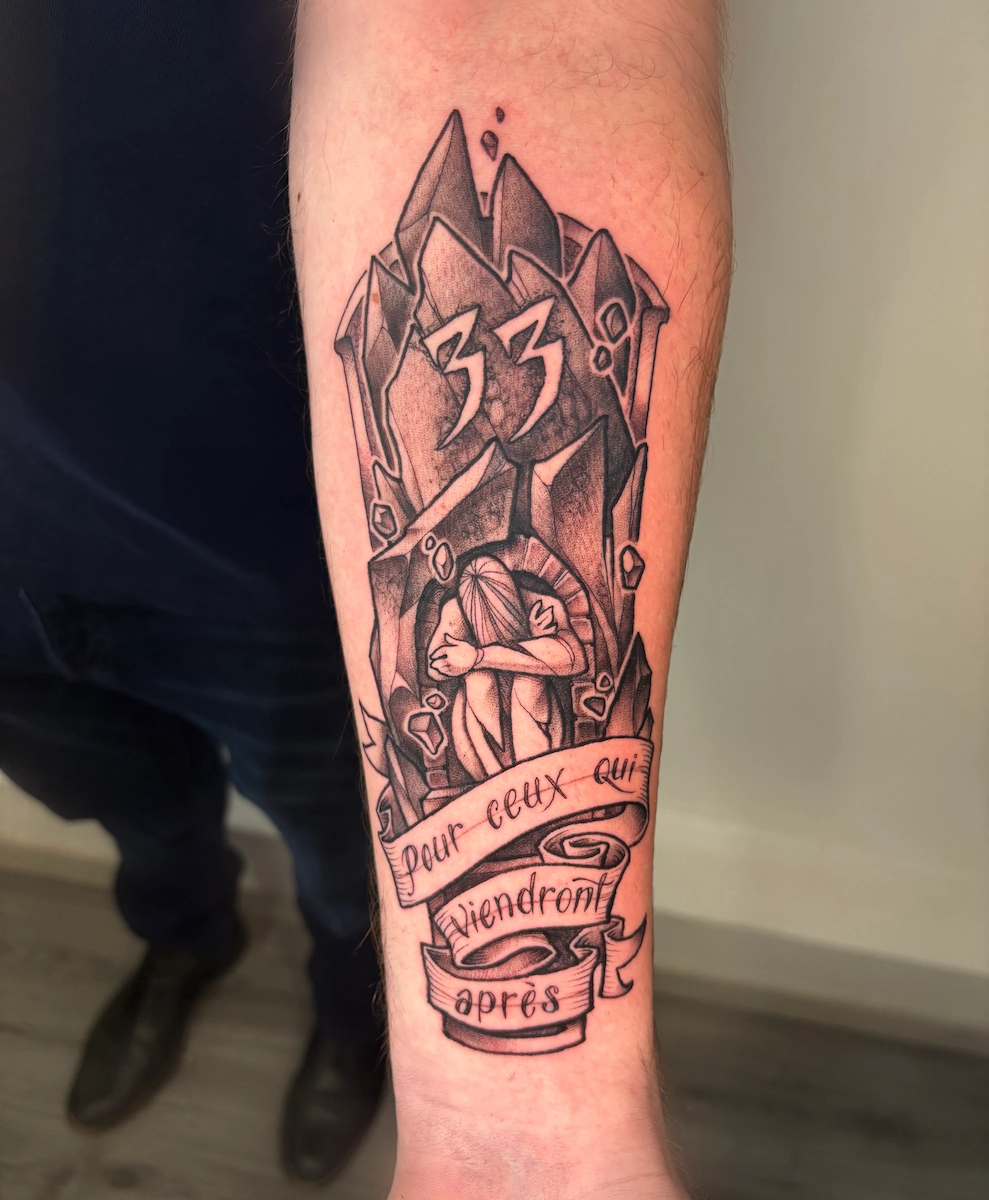 Tatouage noir et gris sur avant-bras représentant la peintresse du jeu Claire Obscure – Jake Tattoo Parlor à Belfort.