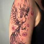 Tatouage noir et gris représentant un phénix accompagné de fleurs de sakura, dans un style fin et féminin – Jake Tattoo Parlor à Belfort.