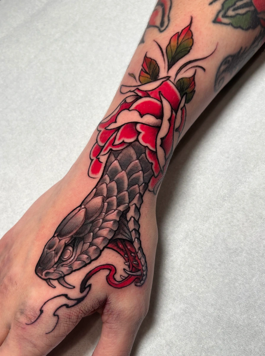 Tatouage de serpent et de rose sur la main – Jake Tattoo Parlor à Belfort.